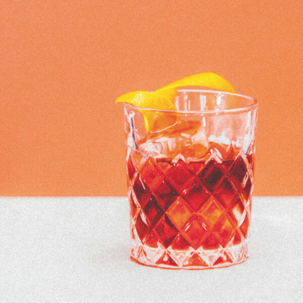 A glass of rose negroni made with Maison Sassy rose cider