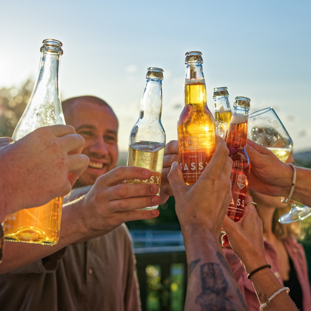 People celebrating with bottles of Maison Sassy Apple Cider